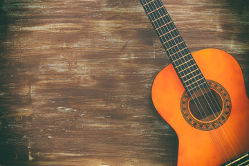 Close up of acoustic guitar against a wooden background