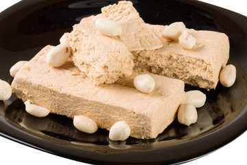 peanut halva on a black plate isolated on white background