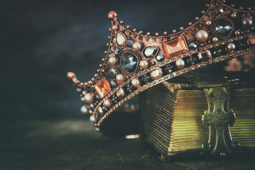 low key image of beautiful queen/king crown on old book