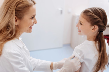 Attractive family doctor vaccinating her patient against diseases