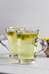 Two cups of herbal tea with coltsfoot (or Tussilago) flowers  