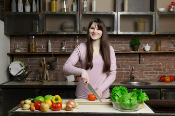 portrait of beautiful woman slice, cutting tomato in the kitchen, cooking, prepare vegetable salad,...