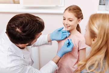 Obraz premium Experienced family doctor doing nose exam