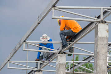 A construction workers installing beam formwork. Formwork is located at the high level that requires the workers to use scaffolding.