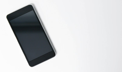 Naklejka premium Flat lay Black mobile phone on the white screen
