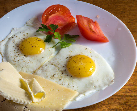 Яичница глазунья с помидорами, сыром и маслом