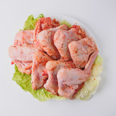 Raw marinated chicken wings on the white plate