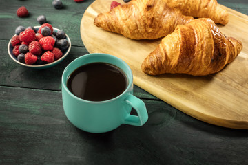 Cup of hot chocolate with croissants and fresh berries