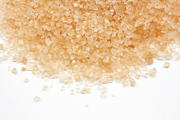 close up of brown sugar produced from sugar cane on white background