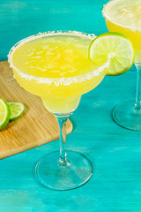 Lemon Margarita cocktails on vibrant turquoise with copyspace