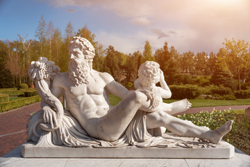 Marble statue of greek god with cornucopia in his hands.