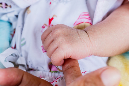 Close-up of newborn child touching mother hand