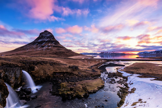 Spring sunrise over the famous Kirkjufellsfoss Waterfall with Kirkjufell mountain in the background in Iceland © ververidis