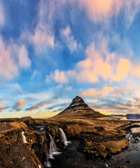 Spring sunrise over the famous Kirkjufellsfoss Waterfall with Kirkjufell mountain in the background in Iceland