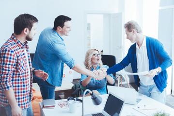 Obraz premium Professional cheerful colleagues holding hands together