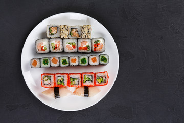 Set of sushi and rolls on black background, top view