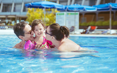 Cheerful family relaxing in the swimming pool