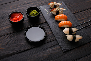 Set of sushi on black wood background, closeup