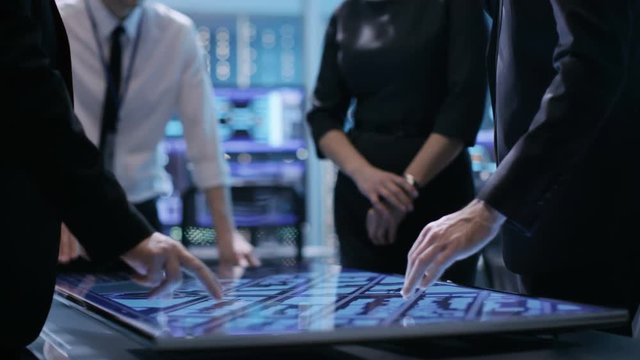Close-up of Surveillance Agency's Agents Hands on Interactive Touchscreen Table, Tracking Dangerous Criminal. They're in Hi-Tech Monitoring Room. Shot on RED EPIC-W 8K Helium Cinema Camera.
