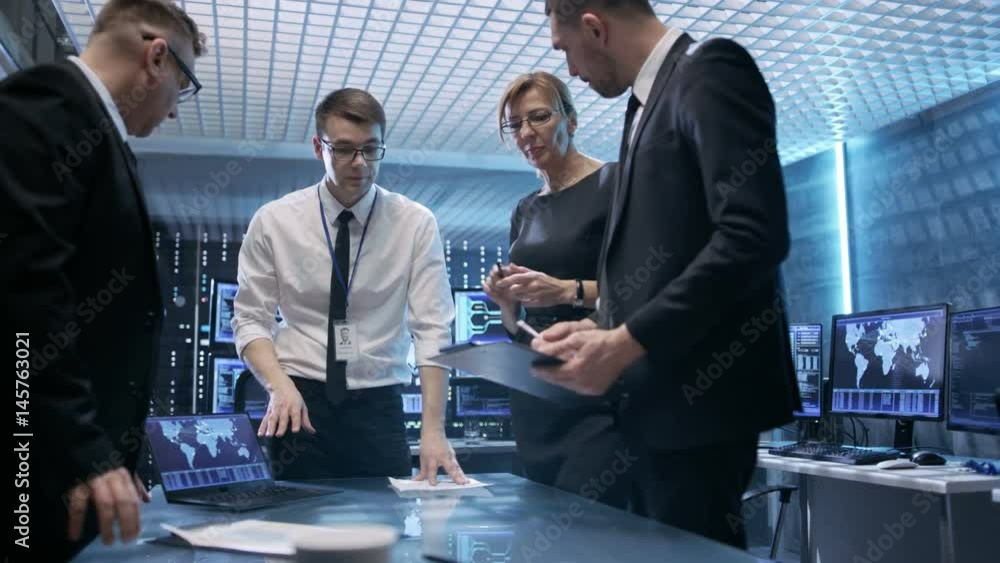 Poster Team of Government Agents Tracking Fugitive with Help of Touchscreen Interactive Table in State of the Art Monitoring Room Full of Computers with Animated Screens. Shot on RED EPIC-W 8K