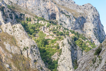 Fototapeta premium View to the village Camarmeña in the mountain range Picos de Europa. Seen from the trackway Canal del Texu, between the village Bulnes and Poncebos, at the river Rio Cares