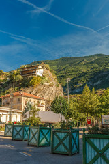 Travelling in Italian Alps - Little alpine town Susa Highly in mountains at hot shiny summer morning with blue cloudy sky