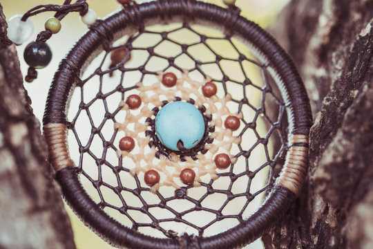 Dreamcatcher on the tree with green natural blurred bokeh background.