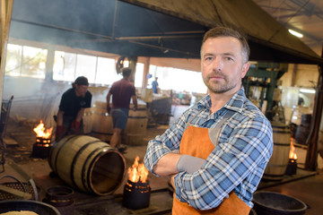 wood barrels production cooper using hammer and tools in workshop