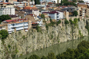 Fototapeta na wymiar Buildings above Kura river in Tbilisi city center aerial view from Narikala Fortress, Georgia.