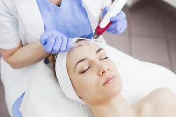 Young beautiful woman in the beauty salon on the face treatment