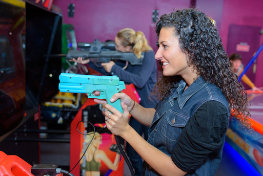 Women holding rifle of arcade game