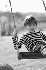 Portrait of a boy on a hanging swing