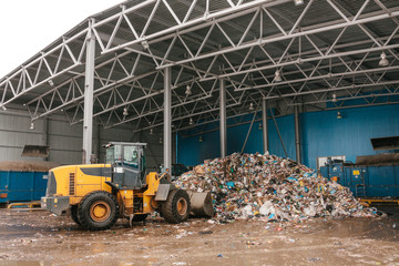 The bulldozer will clean the waste dump. Waste processing plant. Technological process. Business...