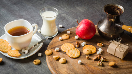 Morning coffee with marshmallows, cookies and milk. Dark wooden background.