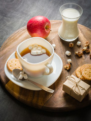Morning coffee with marshmallows, cookies and milk. Dark wooden background.