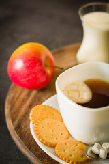 Morning coffee with marshmallows, cookies and milk. Dark wooden background.