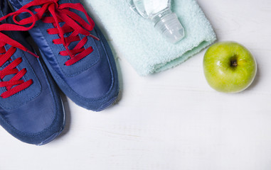 Fototapeta na wymiar Sneakers, a towel, an apple and water