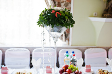 Vase with flowers at wedding tables set.