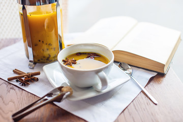 Cup and glass teapot with spicy fruit tea with orange