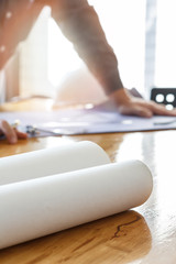 Obraz premium Blueprint on wooden desk with architect background