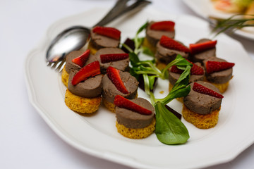 Delicious bruschetta with tomatoes on plate on table close-up Buffet table white plates