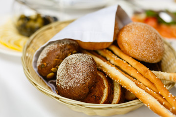 Bread in basket with butter under sunlight Buns bread in a basket table
