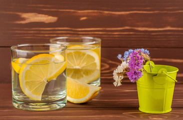water with a lemon on a wooden background