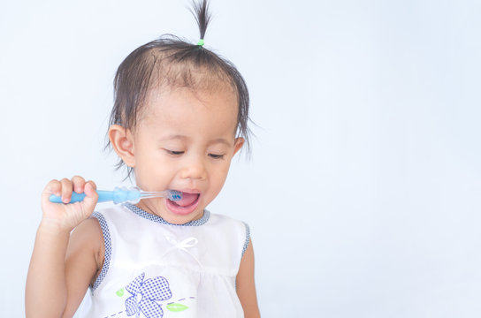 Asian baby girl brushing her teeth