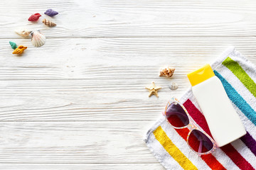 summer vacation concept flat lay. colorful towel, sunglasses, yellow sunscreen and star shells on...