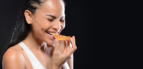 Beautiful girl Middle-aged woman eating tasty pizza on black background