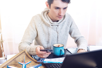 Man holding credit card and buys plane tickets on Internet