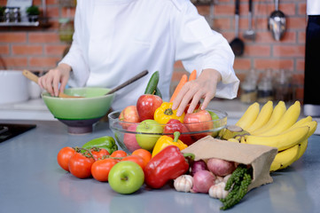 Colorful vegetables and fruits on little chef background in the kitchen