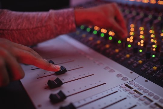 Hands of male audio engineer using sound mixer