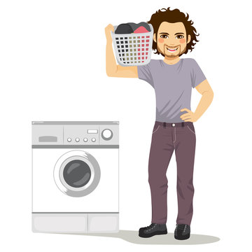 Happy Young Man Holding Laundry Basket Doing Chores With Washing Machine